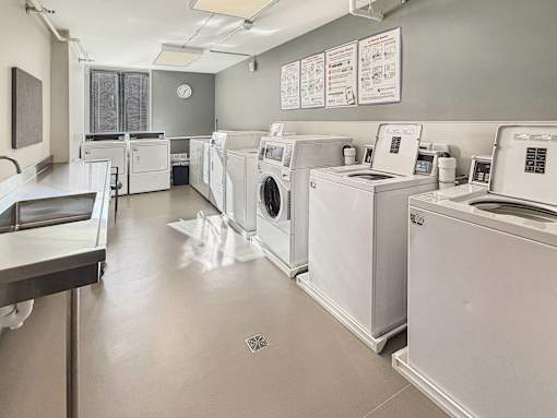 A laundromat with washers and dryers lined up.