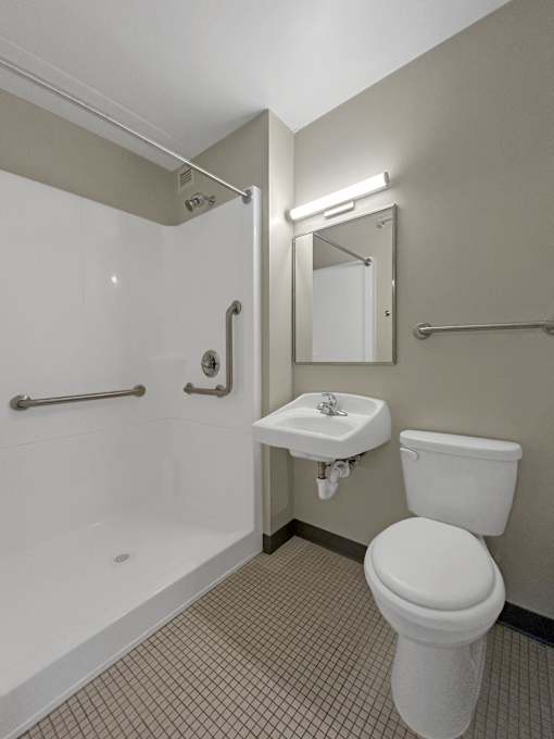 A white toilet sits next to a sink in a bathroom.