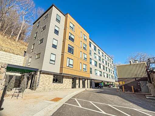 A modern building with a parking lot in front.