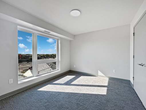 the living room of an apartment with a large window