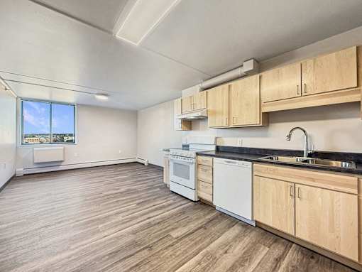 A kitchen with wooden floors and white appliances.