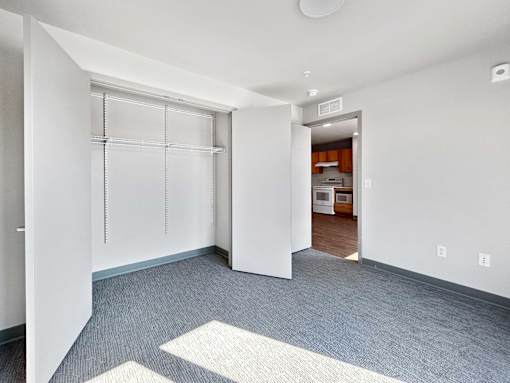 a renovated living room with white walls and white closet doors