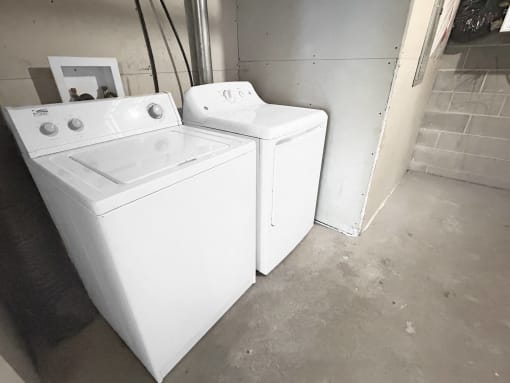 two washers and a dryer sitting in a room