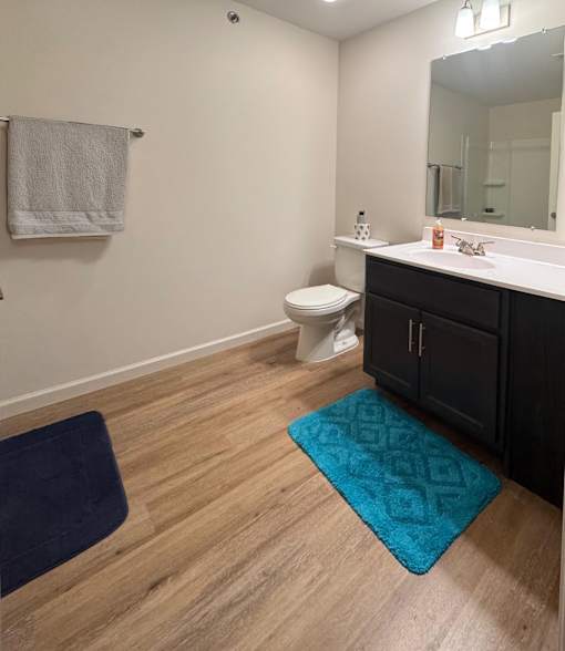 A bathroom with a toilet, sink, and mirror.