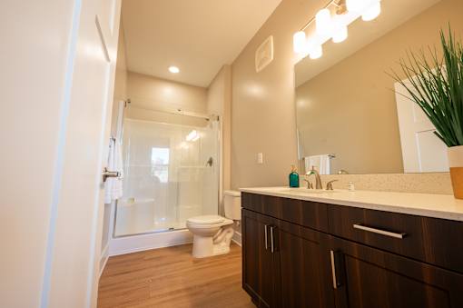 A bathroom with a toilet, sink, and mirror.