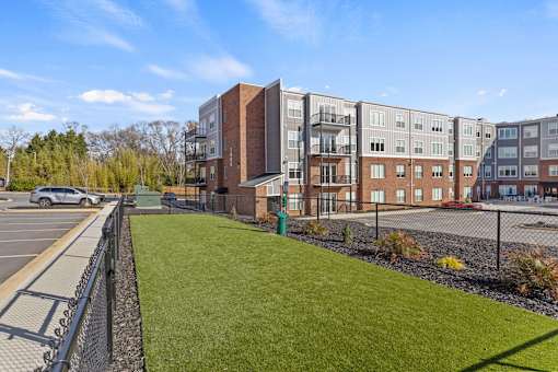 A parking lot is in front of a building with a green lawn.