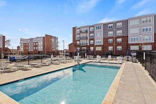 A swimming pool in front of apartment buildings.