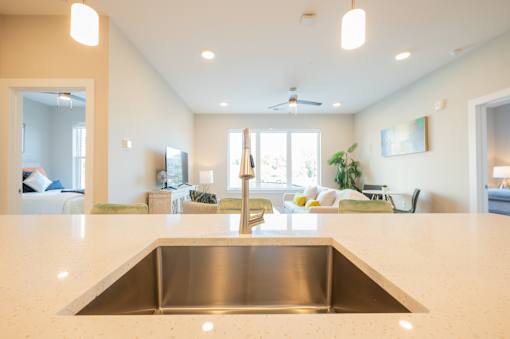 A modern kitchen with a stainless steel sink and a large island.