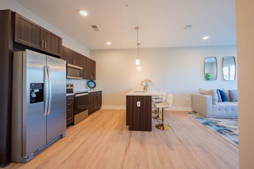 A modern kitchen with a refrigerator, microwave, and oven.