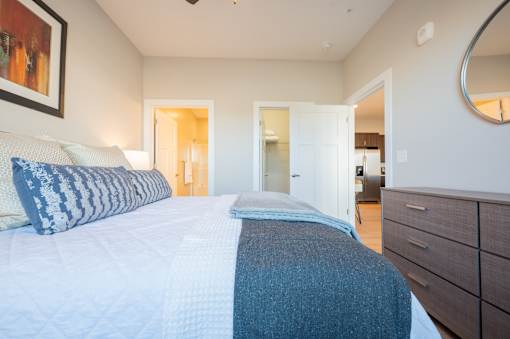 A bedroom with a large bed and a painting on the wall.