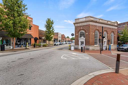 A street view with a building on the right and a car on the road.