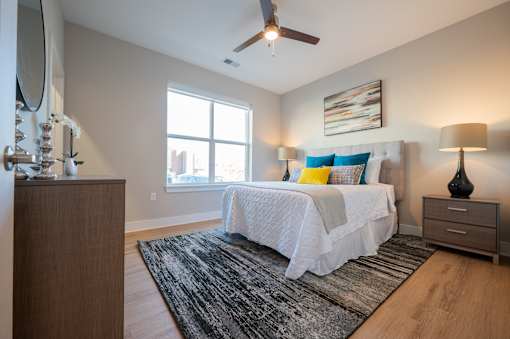 A bedroom with a bed, nightstands, and a rug.