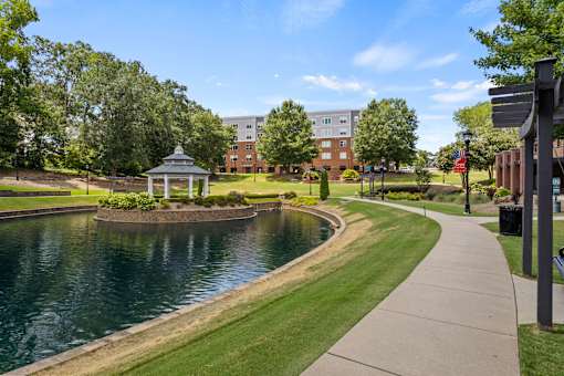 A serene park with a pond, gazebo, and walking path.