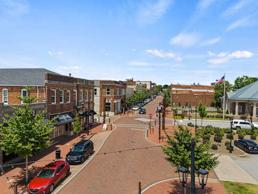 A street view of a town with cars parked on the side of the road.