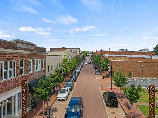 A street view of a town with cars parked on the side of the road.