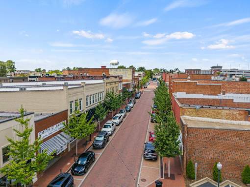 A street view of a town with cars parked on the side of the road.