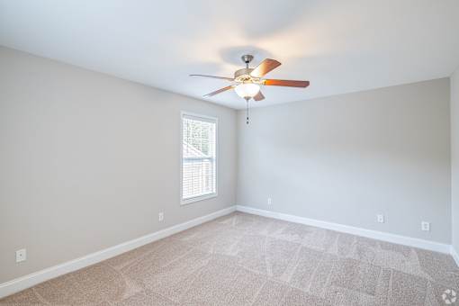 A room with a ceiling fan and a window.