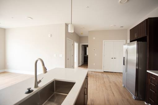 A modern kitchen with a stainless steel refrigerator and a sink with a faucet.