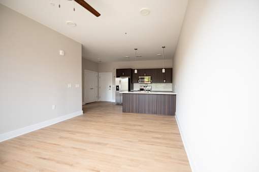 A kitchen with a wooden floor and a ceiling fan.