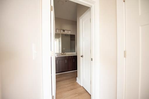 A white door is open to a small kitchen.
