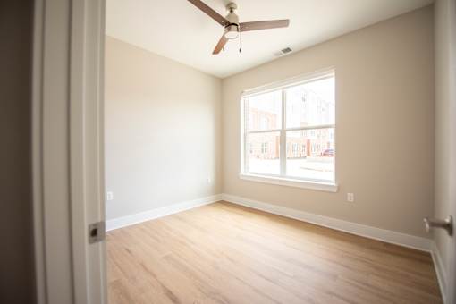 A room with a ceiling fan and a window.