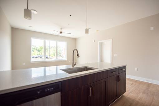 A kitchen with a black dishwasher and a white countertop.