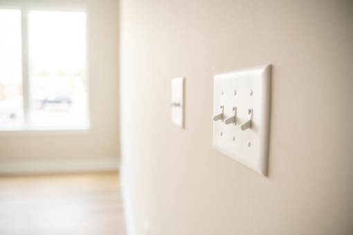Two white switches on a wall.