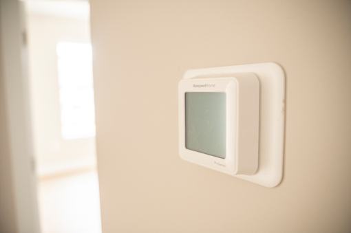 A wall-mounted device with a screen is mounted on a wall.