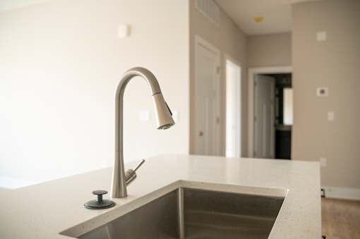 A modern kitchen sink with a chrome faucet.