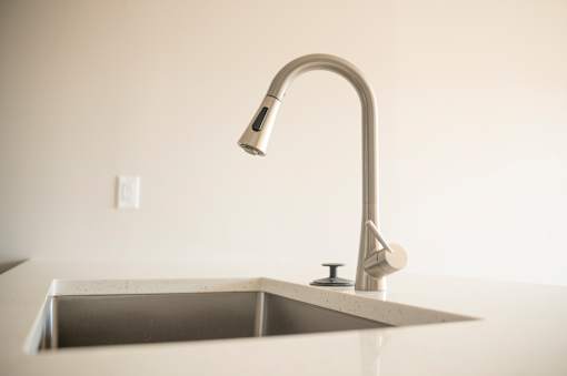 A modern kitchen sink with a chrome faucet.