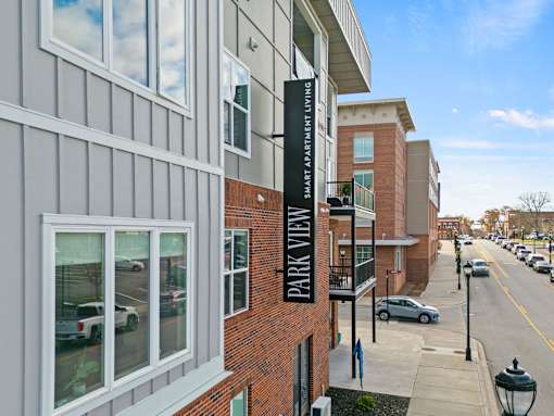 A street view of Park View Department Living with cars parked on the side of the road.