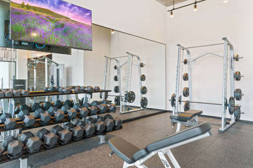 a view of the fitness center with cardio equipment and a large screen tv