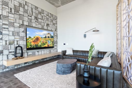 a living room with a large screen tv on the wall