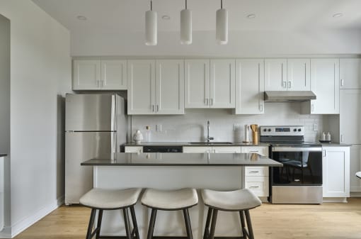 a kitchen with white cabinets and a island with three stools