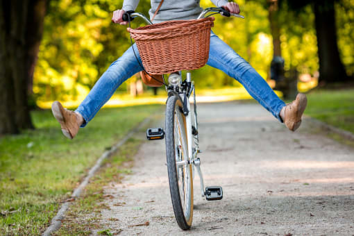 a woman riding a bike with a basket on the front