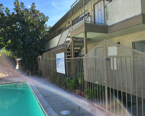 an apartment building with a swimming pool and a fence