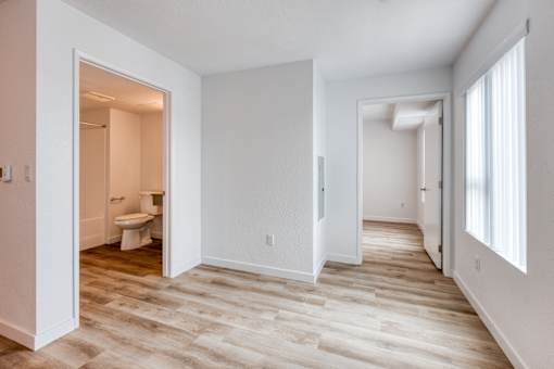 A room with a toilet and sink visible through an open door.