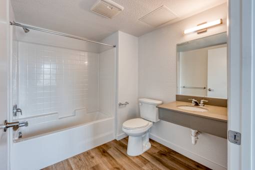A white bathroom with a toilet, sink, and bathtub.