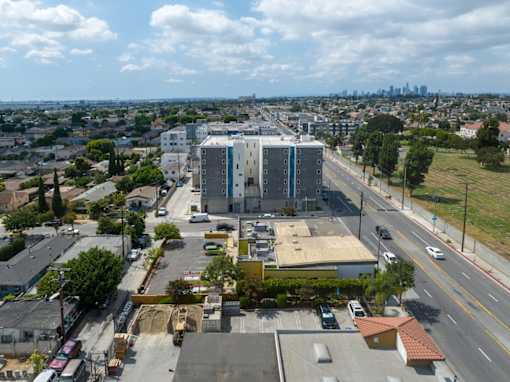 A cityscape with a large building in the center and a highway running through the scene.