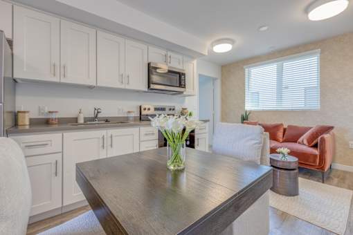 A modern kitchen with a dining table and chairs.