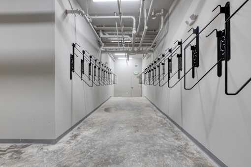 A long hallway with white walls and a marble floor.