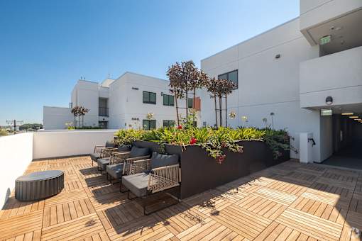 A modern patio with wooden decking and outdoor furniture.