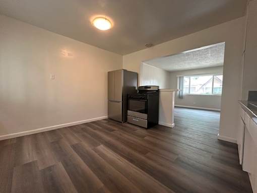 A room with a wood floor and a wall-mounted TV.