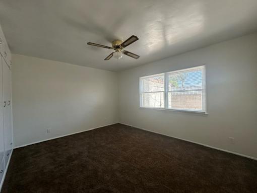A room with a ceiling fan and a window.