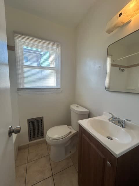 A white toilet sits next to a sink in a small bathroom.