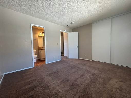 A room with carpeted floor and white walls.