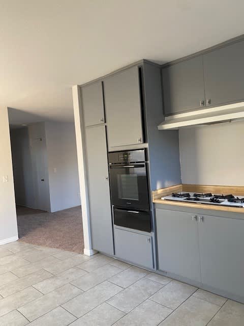 an empty kitchen with a stove and a refrigerator