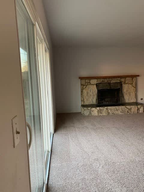 a living room with a fireplace and a sliding glass door