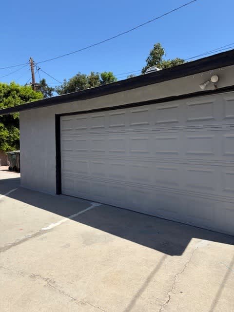 A white garage door is closed and appears to be in good condition.