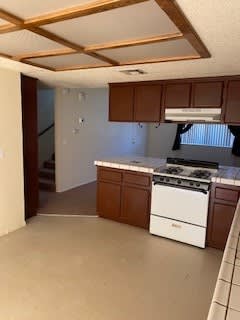 a kitchen with a stove top oven next to a doorway